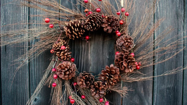 Wreath made from the bristles of a cinnamon broom with pine cones and berries as accents