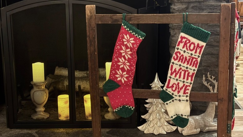 Red and green Christmas stockings hung on a vintage quilt rack
