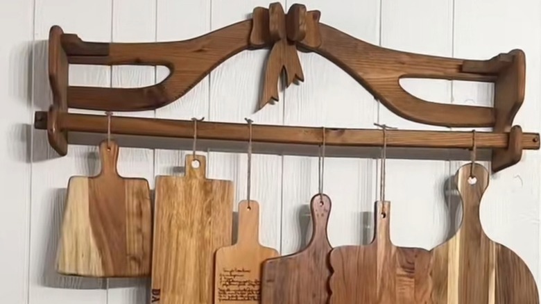 Wooden quilt rack mounted on wall used to hang cutting boards