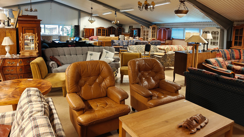 Thrift store filled with various food furniture including china cabinet, chairs, and mroe.