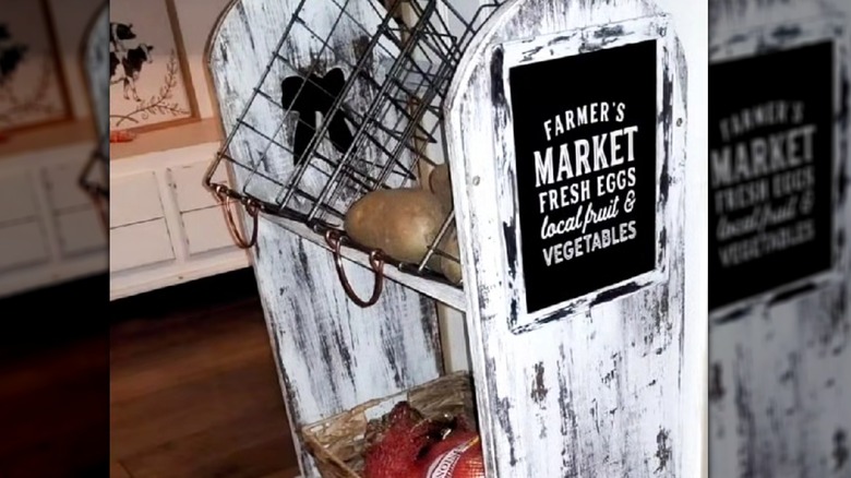 Quilt rack turned into a produce stand for kitchen with a whitewash  "farmer's market" sign along with wire baskets