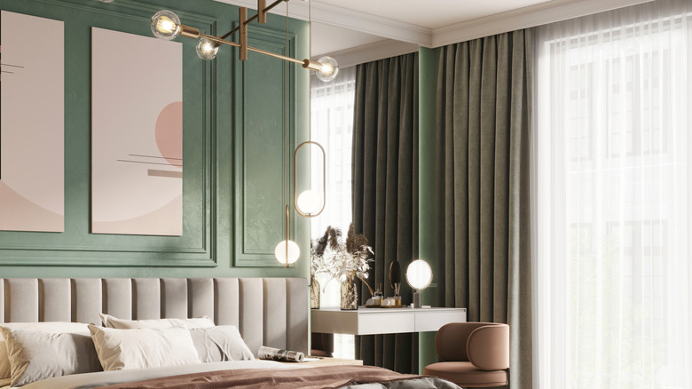 Green walls with gray curtains in a bedroom.