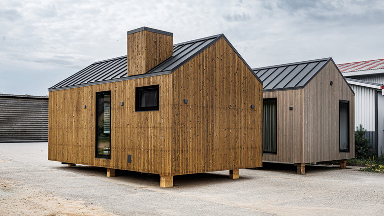 A pair of prefabricated, modular tiny home sitting side by side on a lot.