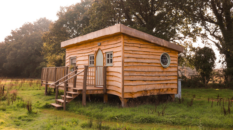 A tiny wooden cabin in the woods of England.