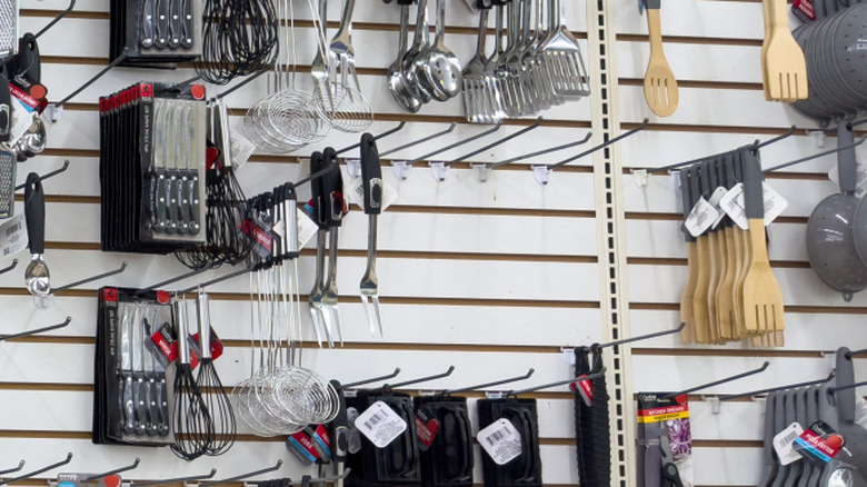 A BBQ fork and other assorted kitchen gadgets on a display wall at Dollar Tree.