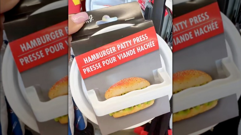 A hand holding a hamburger patty press while in-store at Dollar Tree.