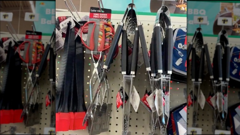 Assorted tongs hanging on a display shelf in Dollar Tree.