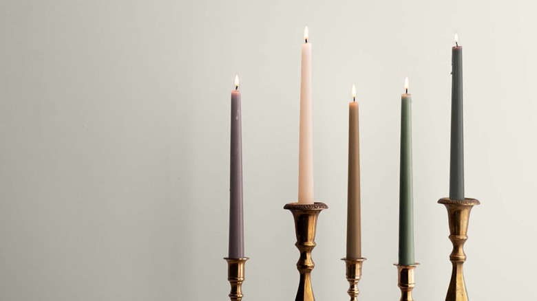 Candles sitting in front of a wall painted creamy white.