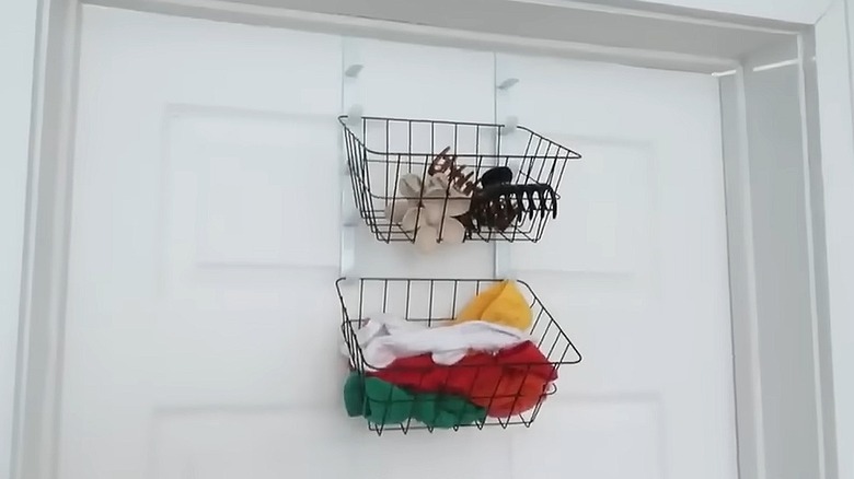 Dollar Tree baskets with hair accessories in them hanging on over-the-door hooks