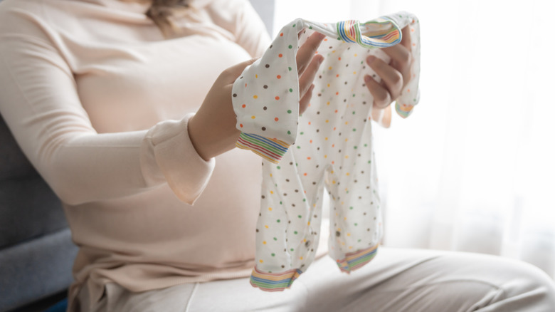 Woman holding baby outfit