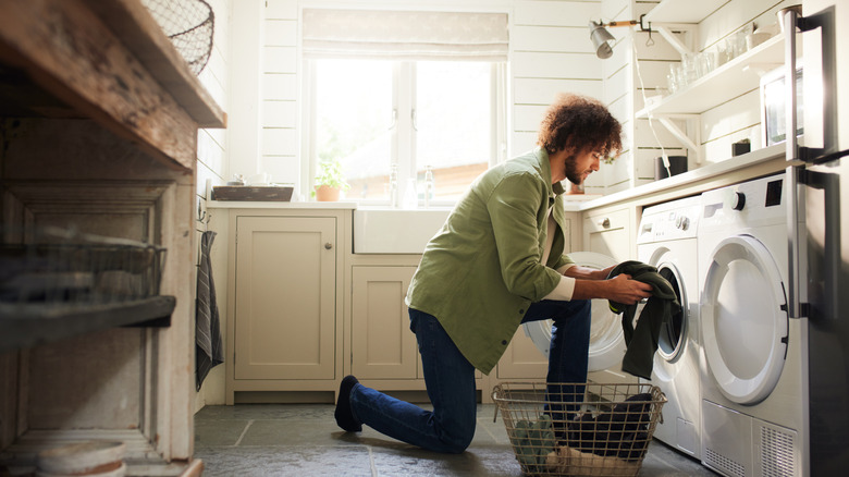 Man with curly hair washing laundry