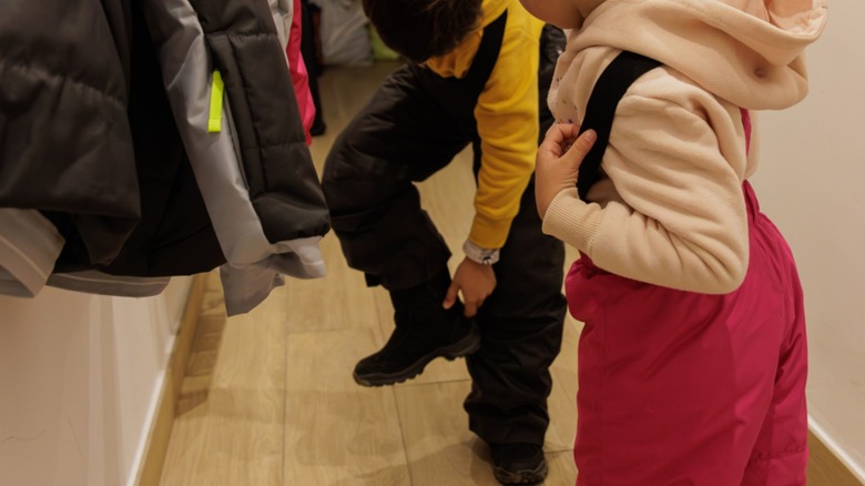 Kids putting on snow pants