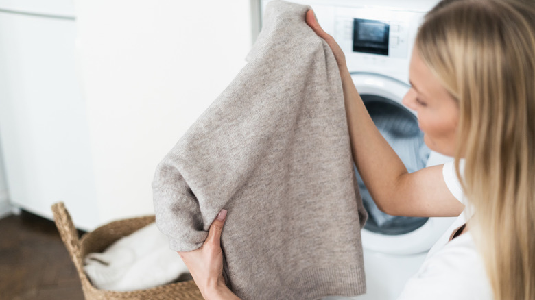 Blonde woman washing wool sweater