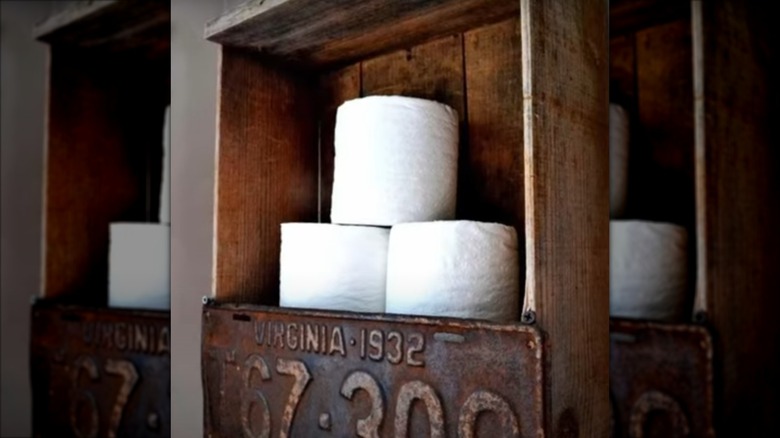 Toilet paper rolls in a wooden box shelf