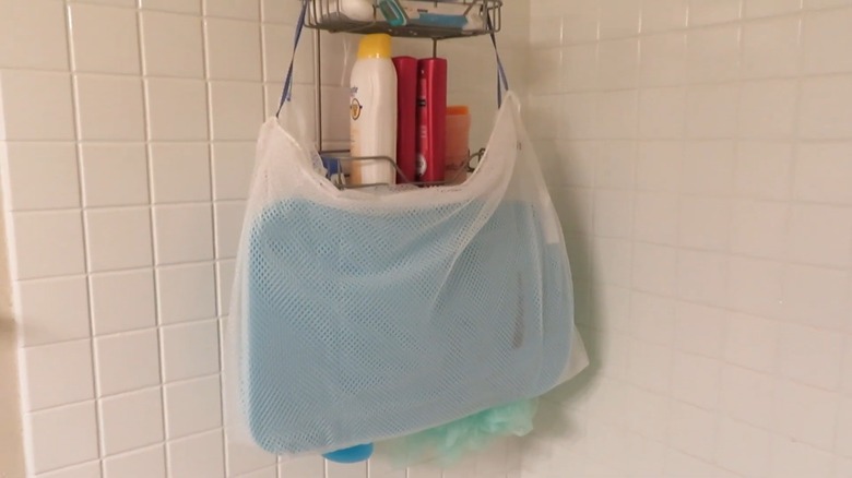 A wet baby bath sponge in a mesh laundry bag