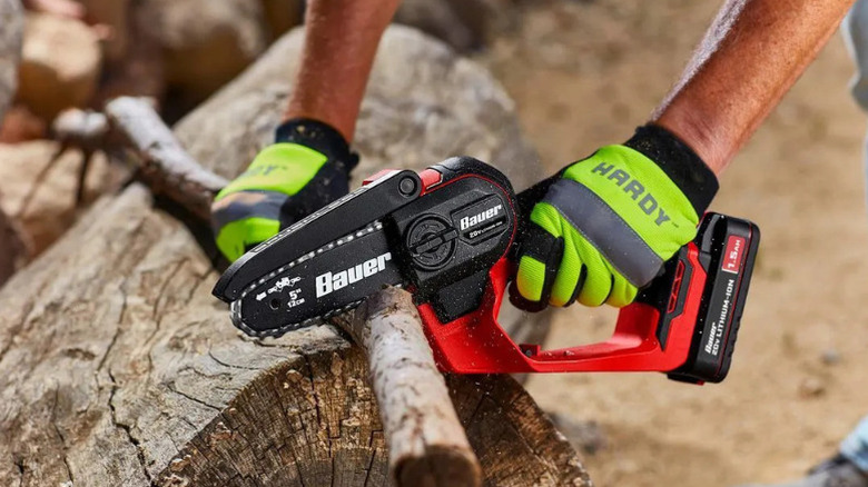 Close-up of a person using Bauer's 20V Brushless Cordless, 5 inch Pruning Saw