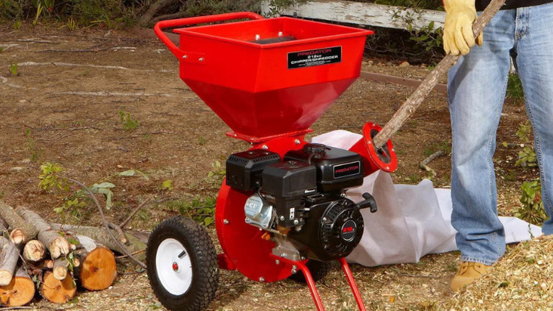 A person using Predator's 6.5 Horsepower (212cc) Chipper Shredder