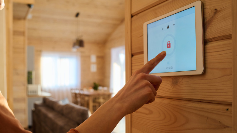 A finger turning an alarm system on.