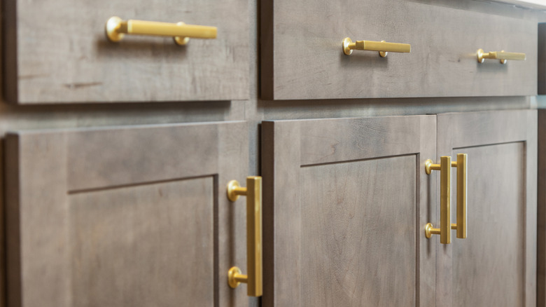 Gold hardware on kitchen cabinets.