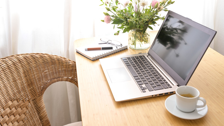 Computer desk with a computer and coffee on it.