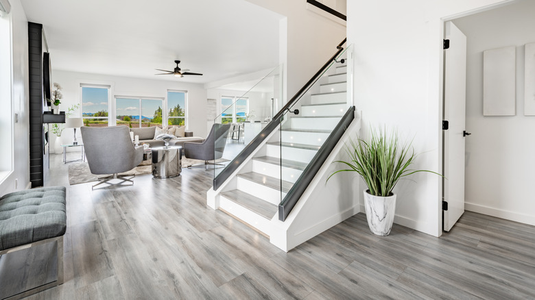 An entryway and living room with gray vinyl flooring throughout