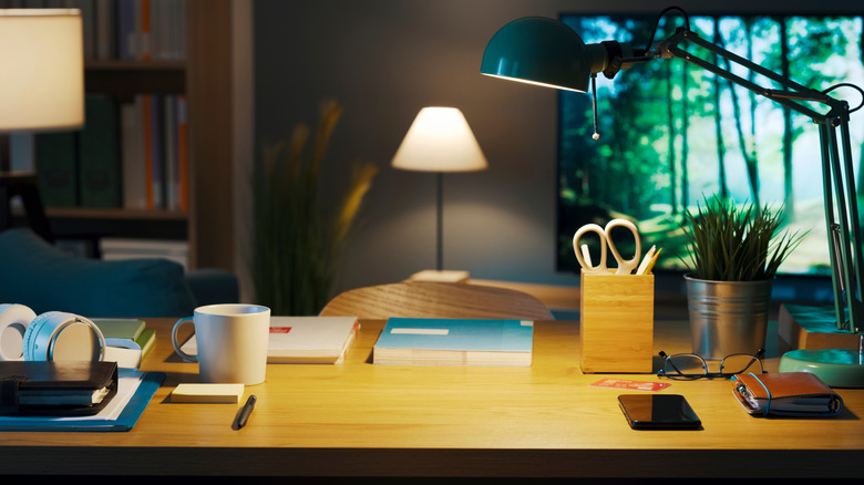 Desk with an adjustable lamp and several lamps in the background