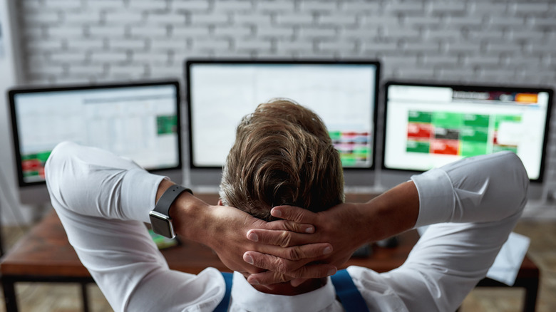 Man sitting at a desk with multiple monitors