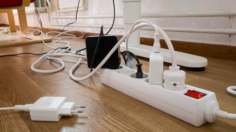Power strip with cords plugged in sitting on the floor