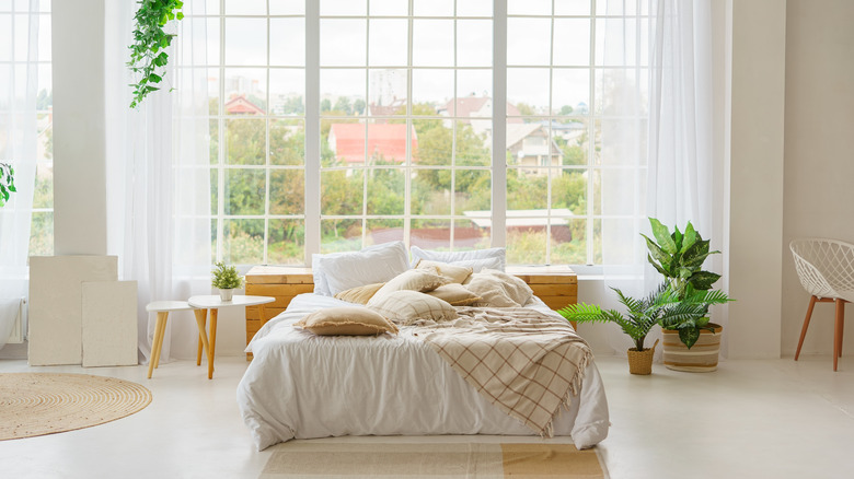 A bedroom with lots of windows