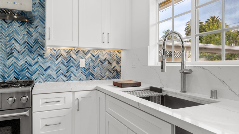 A kitchen with blue tile backsplash