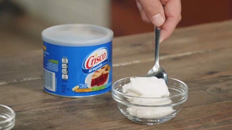 crisco shortening on table beside small bowl with shortening inside