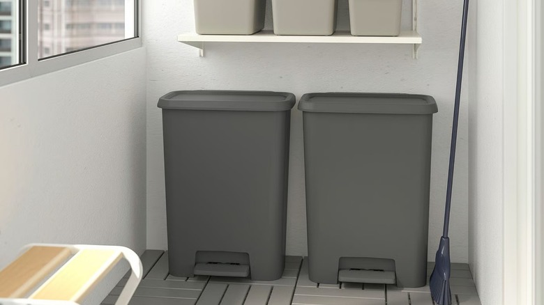 Two KNÖCKLA Step trash cans under storage shelves