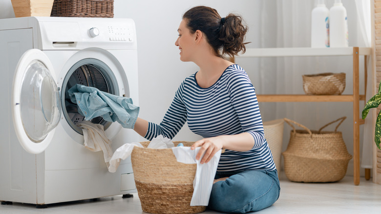 Person putting clothes in laundry