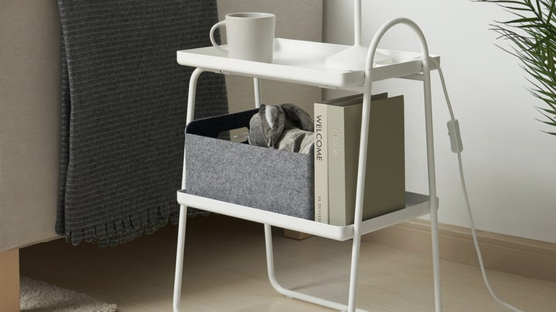 IKEA HATTÅSEN Bedside Table next to a couch with a lamp, mug, and books