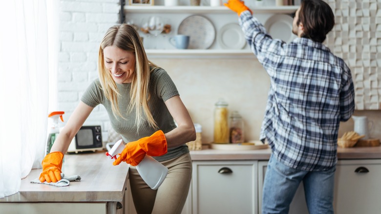 Two people cleaning kitchen together
