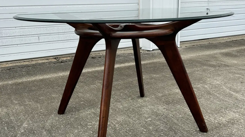 A glass top coffee table with wooden base from Craft Associates