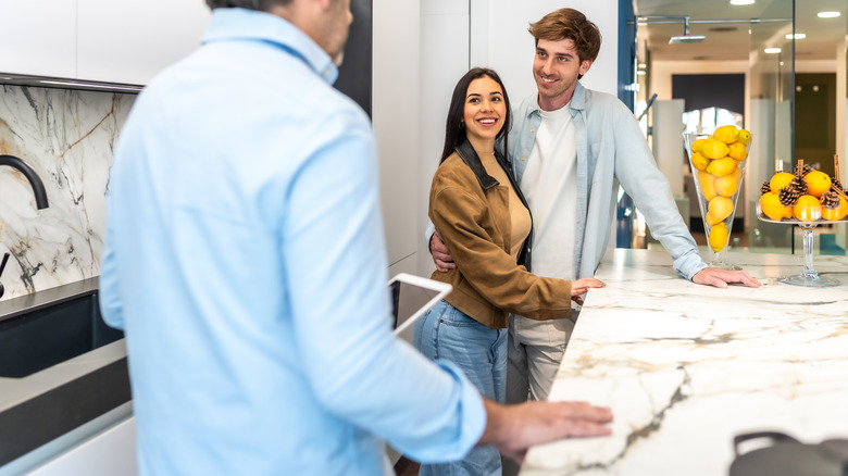 Couple talking with a marble supplier in a showroom
