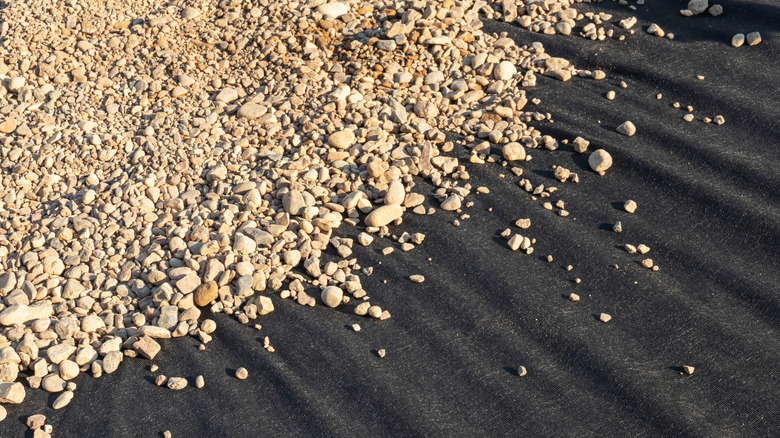 gravel spreading over landscaping fabric