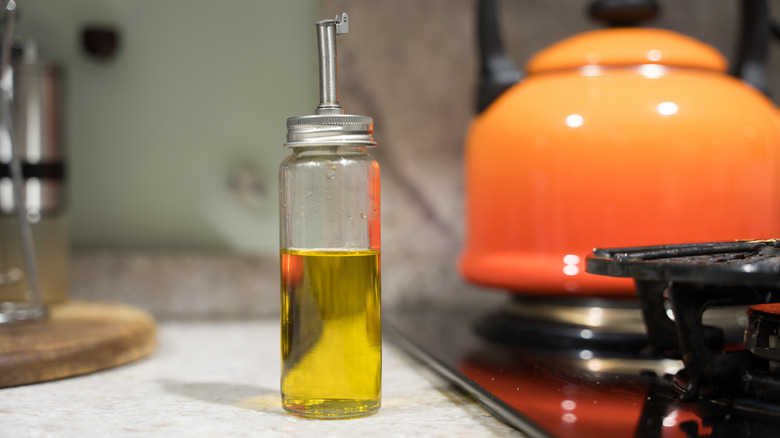 Bottles of olive oil on the countertop next to a range top