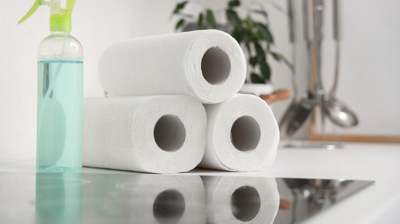 Rolla of paper towel and spray cleaner near oven hob