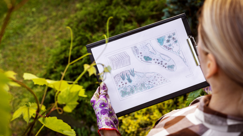 A woman looks at a landscaping design plan