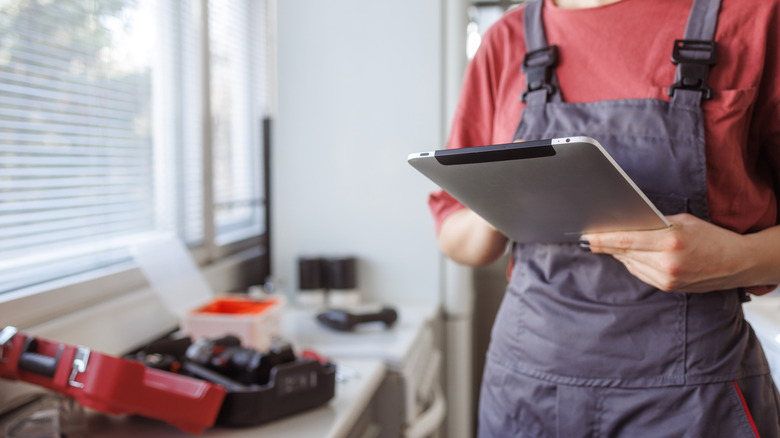 Woman working on maintenance and holding a tablet