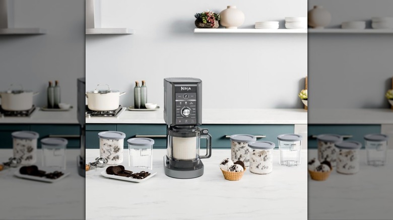 Ice cream maker with tubs filled sitting on counter.