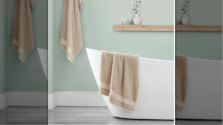 Costco bath sheets hanging in a bathroom with bath tub.