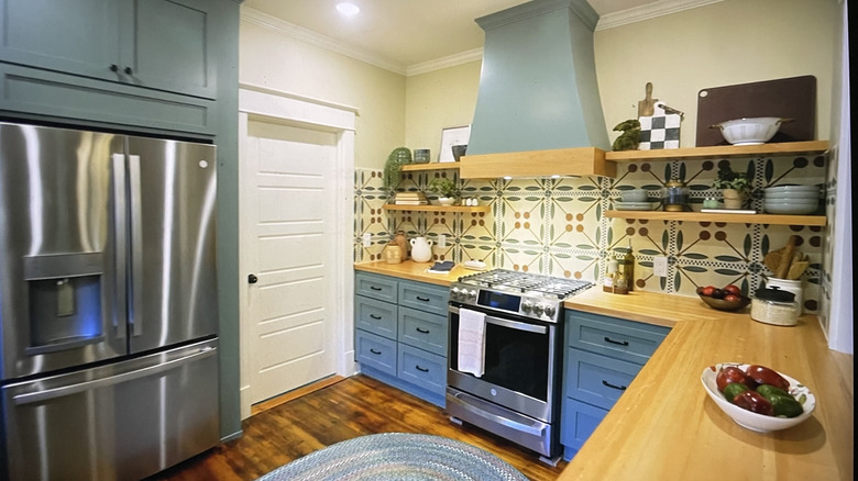 A funky kitchen with stainless steel appliances and playful geometric tile backsplash