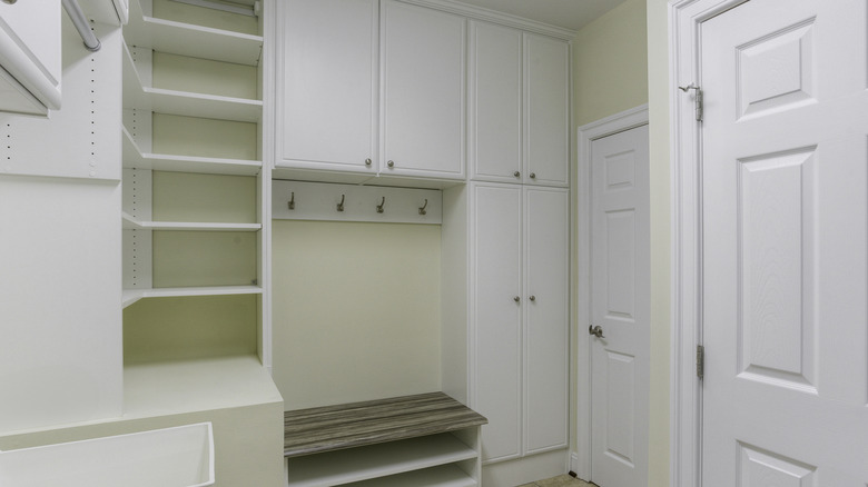 Mudroom with built-in storage shelves, cabinets, and a bench