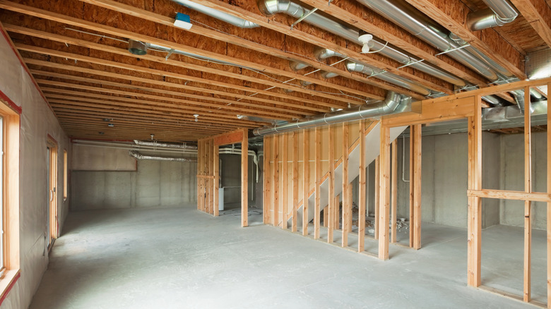 An unfinished basement with studs for walls installed