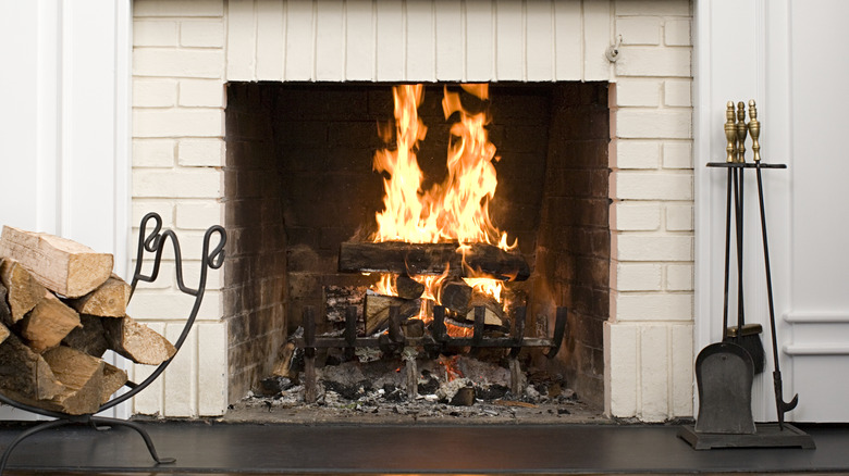 Updated fireplace with decorative log holder and fireplace tools