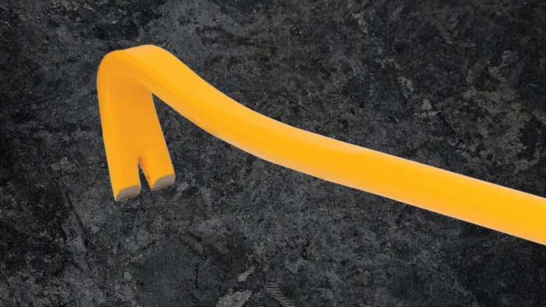Close-up of tri-lobe prying end of DeWalt wrecking bare on stonellike surface
