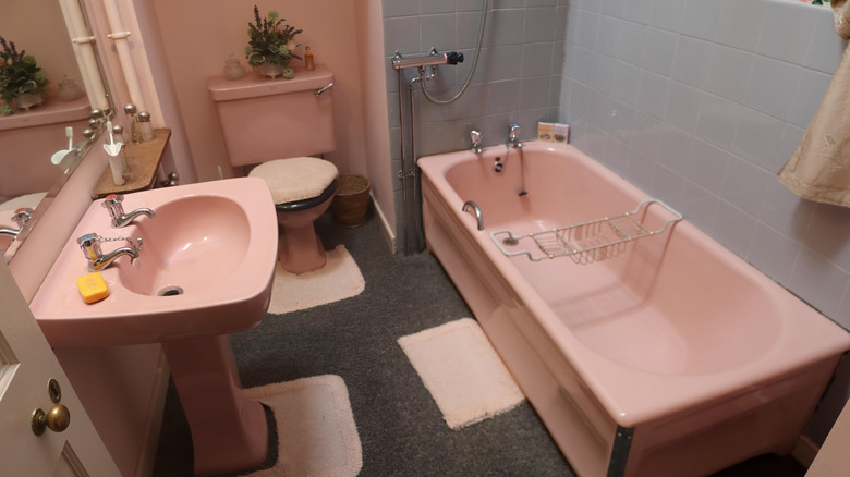 Vintage carpeted bathroom with pink fixtures